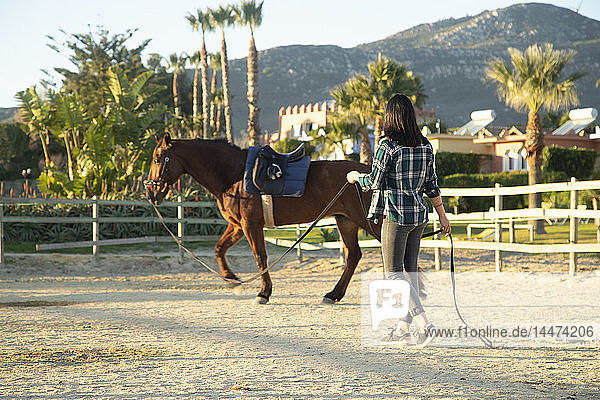 Spanien  Tarifa  Frau führt Pferd auf dem Reitplatz