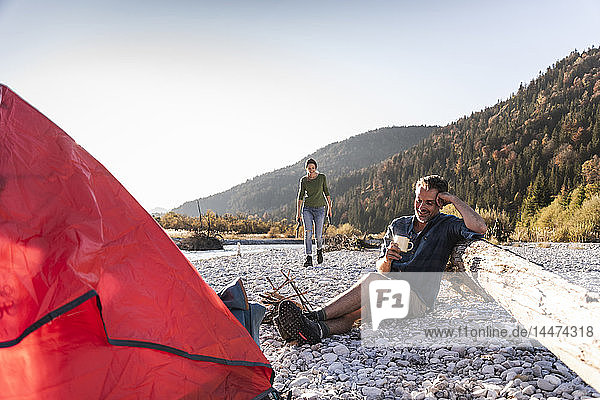 Mature couple camping at riverside in the evening light