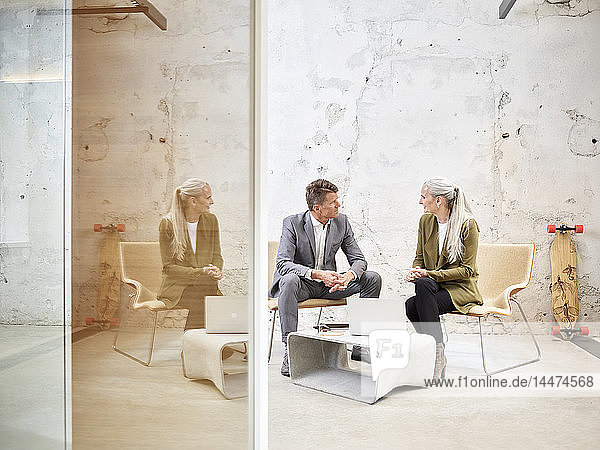 Businessman and businesswoman talking in modern office