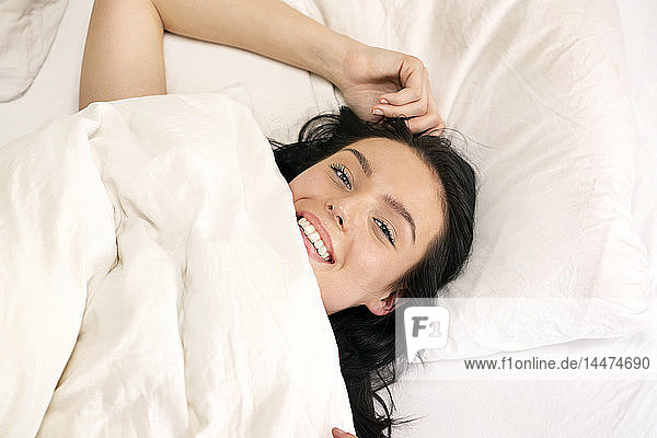 Beautiful woman lying in bed  smiling  portarit