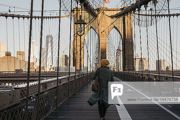 USA  New York  New York City  Touristin auf der Brooklyn Bridge im Morgenlicht
