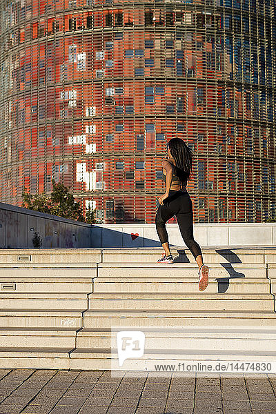 Young woman running up stairs in the city
