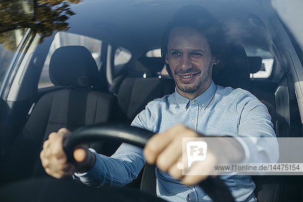 Lächelnder Geschäftsmann beim Autofahren