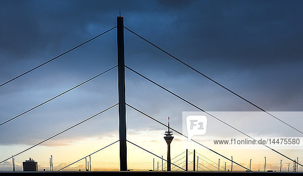 Deutschland Düsseldorf Oberkasselbrücke mit Fernsehturm im Hintergrund in der Dämmerung