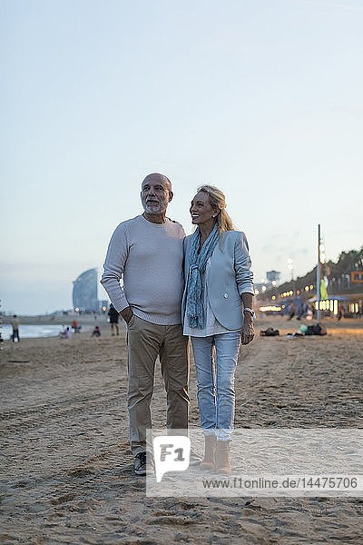 Spain  Barcelona  happy senior couple on the beach at dusk