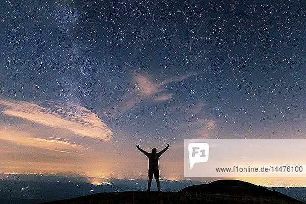 Italien  Monte Nerone  Silhouette eines Mannes  der den Nachthimmel mit Sternen und Milchstraße betrachtet