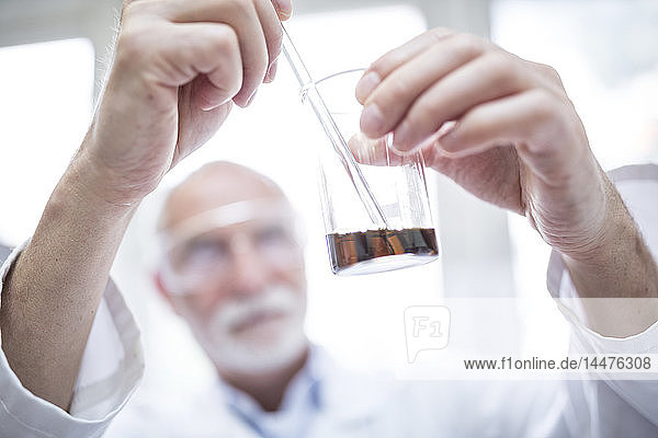 Man holding beaker in laboratory