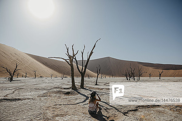 Namibia  Namib-Wüste  Namib-Naukluft-Nationalpark  Sossusvlei  Frau  die in Deadvlei sitzt