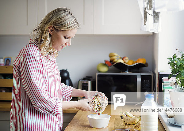 Frau bereitet zu Hause das Frühstück in der Küche vor