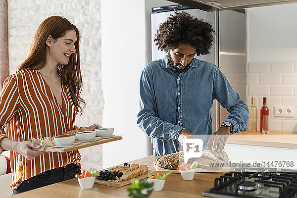 Couple standing in kitchen  preparing dinner party
