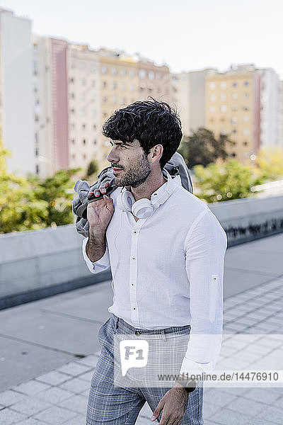 Young man with headphones in the city on the go
