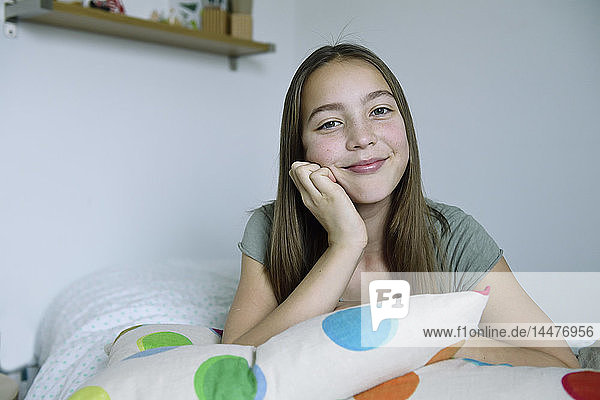 Porträt eines lächelnden Mädchens auf dem Bett liegend