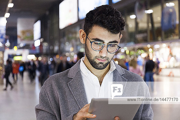 Deutschland  München  Porträt eines jungen Geschäftsmannes mit digitalem Tablet am Hauptbahnhof