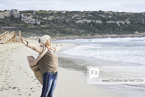 Spanien  Menorca  glücklicher älterer Mann  der im Winter an der Meeresküste steht