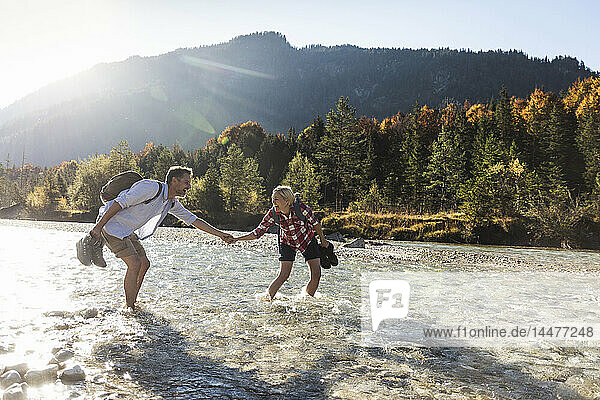 Austria  Alps  couple on a hiking trip wading in a brook