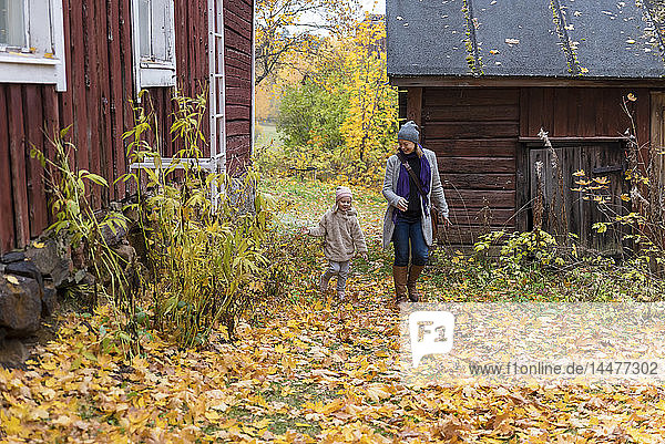 Finnland  Kuopio  Mutter und kleine Tochter spielen im Herbst zusammen