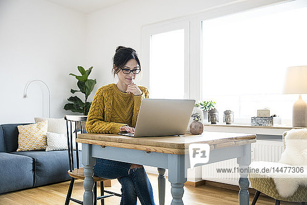 Woman sitting at table  using laptop