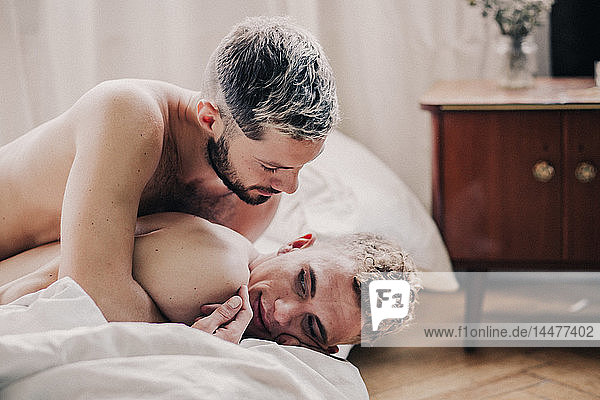 Gay couple embracing in bed
