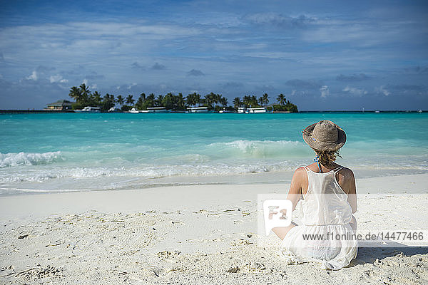 Malediven  Ari Atoll  Nalaguraidhoo  Sun Island Resort  Rückenansicht der am Strand sitzenden Frau
