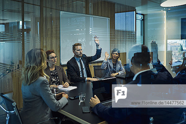 Group of business people voting during meeting