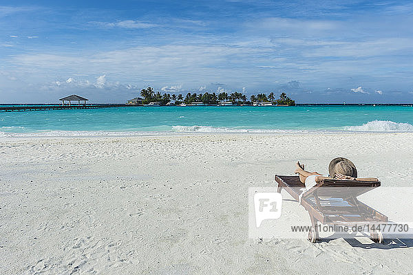 Malediven  Ari Atoll  Nalaguraidhoo  Sun Island Resort  Rückenansicht einer Frau  die sich am Strand entspannt