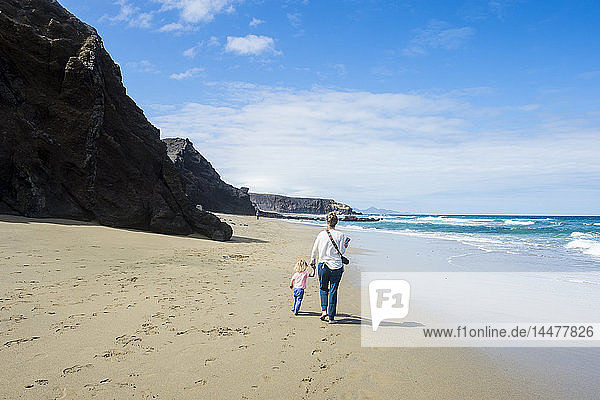 Spain  Canary Islands  Fuerteventura  La Pared  Playa del Viejo Rey  mother and daughter walking on the beach