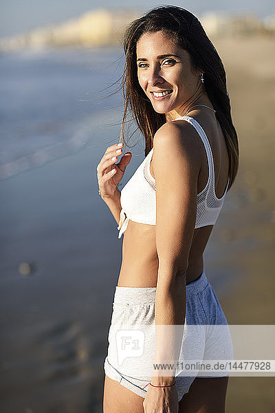 Porträt einer lächelnden schönen Frau am Strand