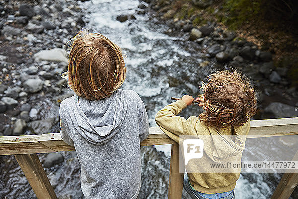 Chile  Patagonien  Vulkan Osorno  Wasserfall Las Cascadas  zwei Jungen stehen auf einer Brücke über einem Fluss