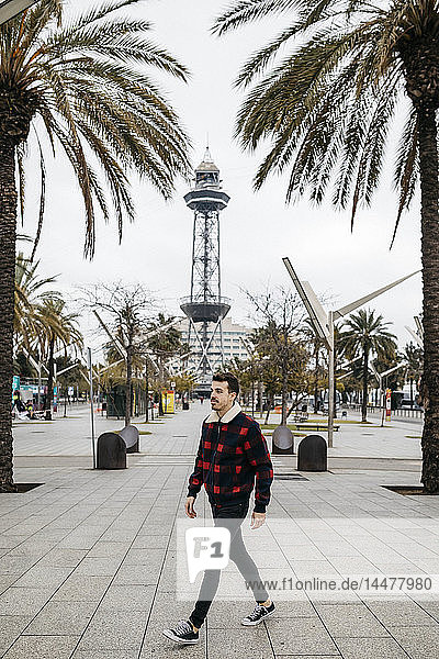 Spanien  Barcelona  Junger Mann in Freizeitkleidung geht auf einem Platz
