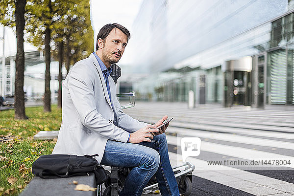 Businessman sitting on a bench  using digital tablet