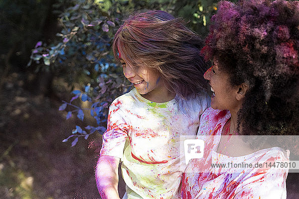 Mutter und Sohn voller bunter Pulverfarbe  feiern Holi  Fest der Farben