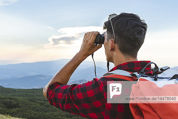 Italy  Monte Nerone  hiker in the mountains looking with binocular