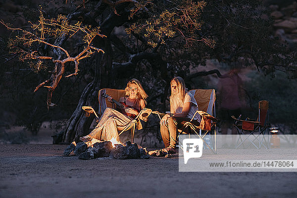 Namibia  Freunde sitzen am Lagerfeuer und spielen Gitarre