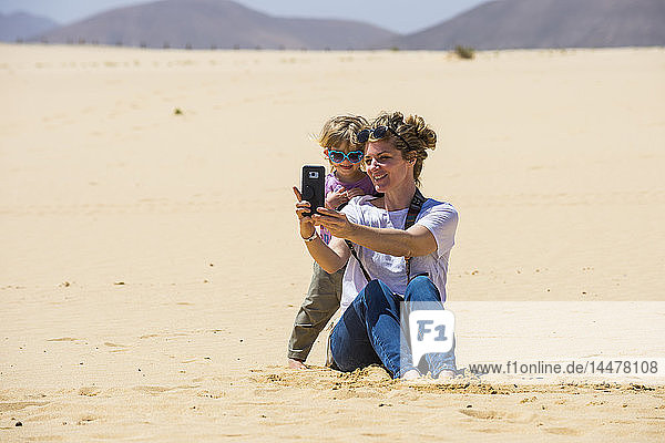 Spanien  Kanarische Inseln  Fuerteventura  Parque Natural de Corralejo  Mutter und Tochter beim Selfie in den Sanddünen