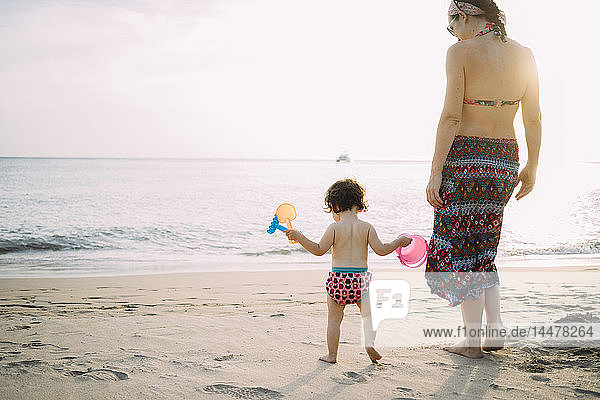 Thailand  Koh Lanta  Rückenansicht des Mädchens und der Mutter am Strand bei Sonnenuntergang