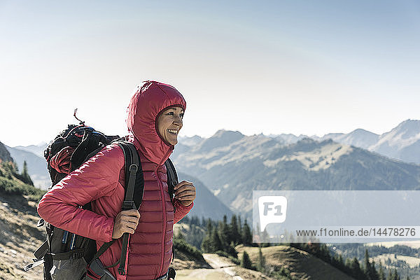 Austria  Tyrol  smiling woman on a hiking trip in the mountains enjoying the view