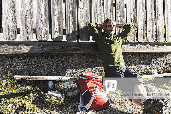 Der reife Mann entspannt sich auf einer Berghütte und genießt die Sonne