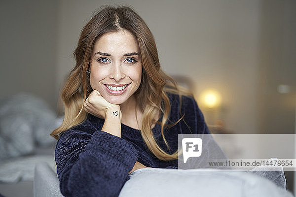 Portrait of smiling young woman on couch