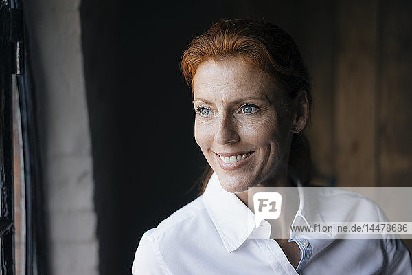 Porträt einer lächelnden Geschäftsfrau  die zur Seite schaut
