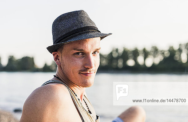 Portrait of young man wearing a hat at the riverbank
