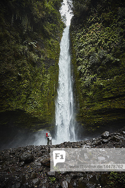 Chile Patagonien Vulkan Osorno Mutter und Sohn stehen am Wasserfall Las Cascadas