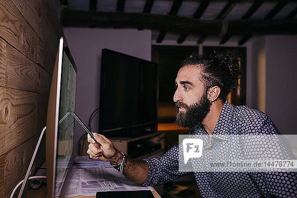 Young architect working hard on a new project at home at night