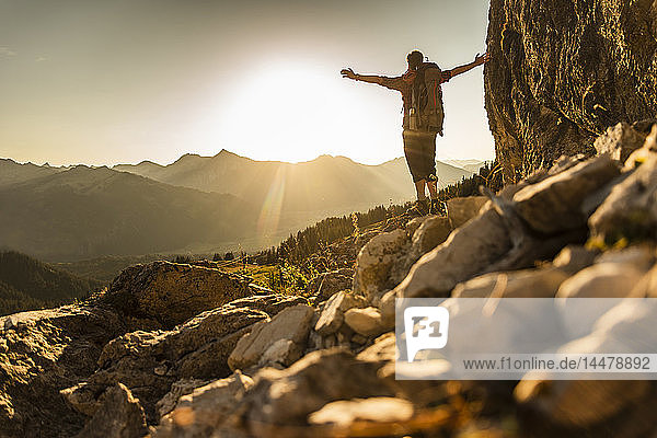 Hiking man standing in he mountains  cheering