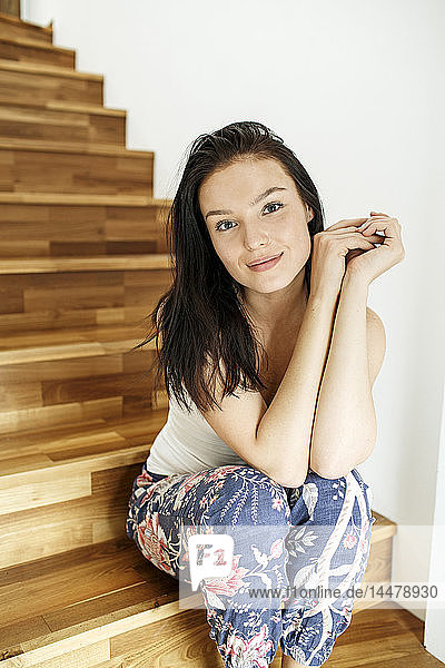 Pretty woman sitting on stairs at home  portrait