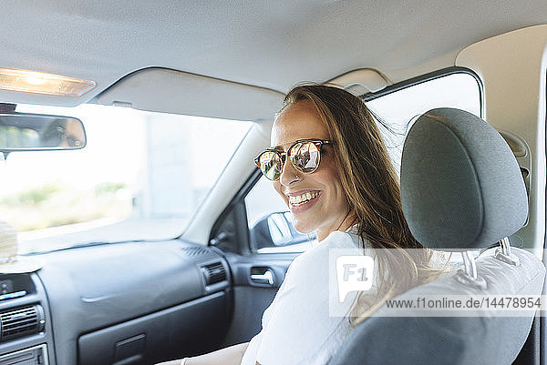 Glückliche Frau auf Beifahrersitz im Auto