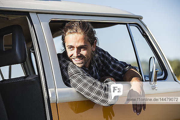 Junger Mann mit seinem Wohnwagen auf einer Autoreise