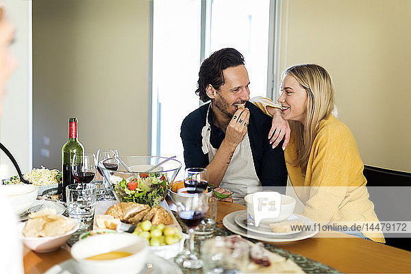 Friends having fun  eating lunch together  couple flirting at the table