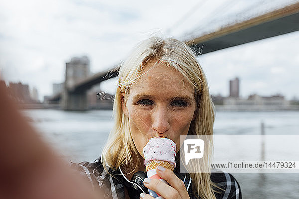 USA  New York City  Brooklyn  Selfie einer jungen Frau am Hafen beim Eisessen