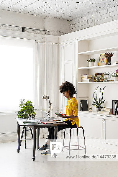 Woman sitting at desk  working  using laptop