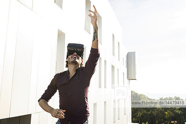 Mann auf einer Dachterrasse  Spielen mit VR-Brille